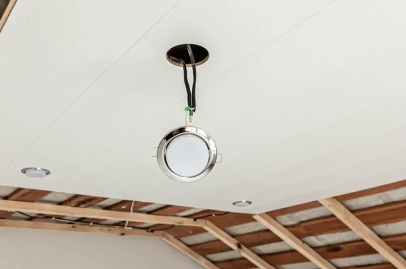 Inbouwspot wordt aangesloten in een verlaagd plafond