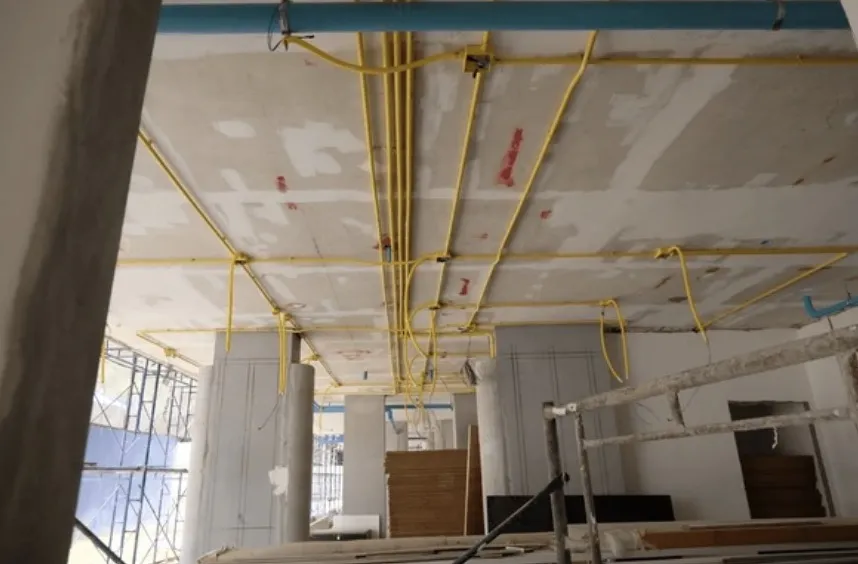 Elektraleidingen tegen het plafond van een bedrijfspand in aanbouw